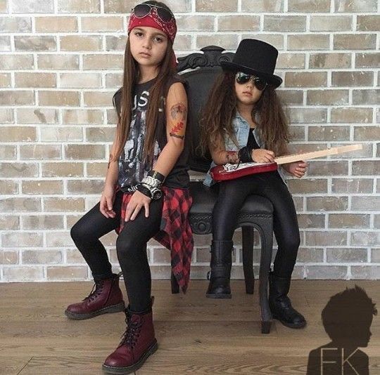 Dwie dziewczynki w stylizacjach rockowych na tle ceglanej ściany.